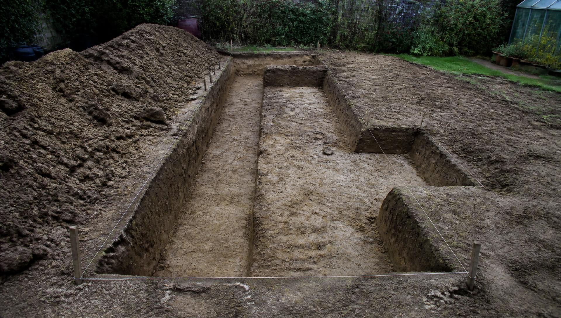 Freshly dug strip foundation trenches with string lines set out in a rear garden